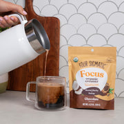 How to Use: Chocolate creamer being frothed into a mug of coffee.