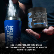 Applied Nutrition supplement container with ABE pre-workout powder being poured into it.